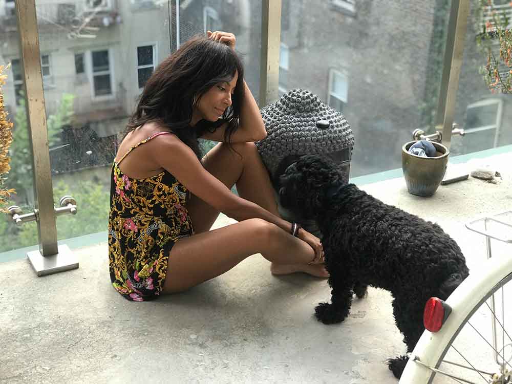 A woman sitting on the ground with her dog.